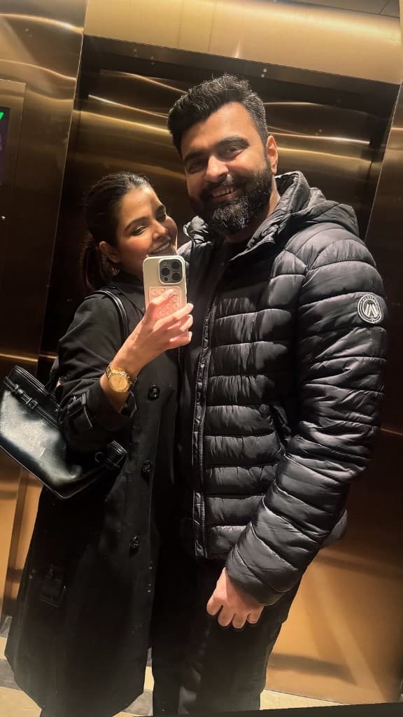 Charu and Alok smiling in an elevator mirror selfie